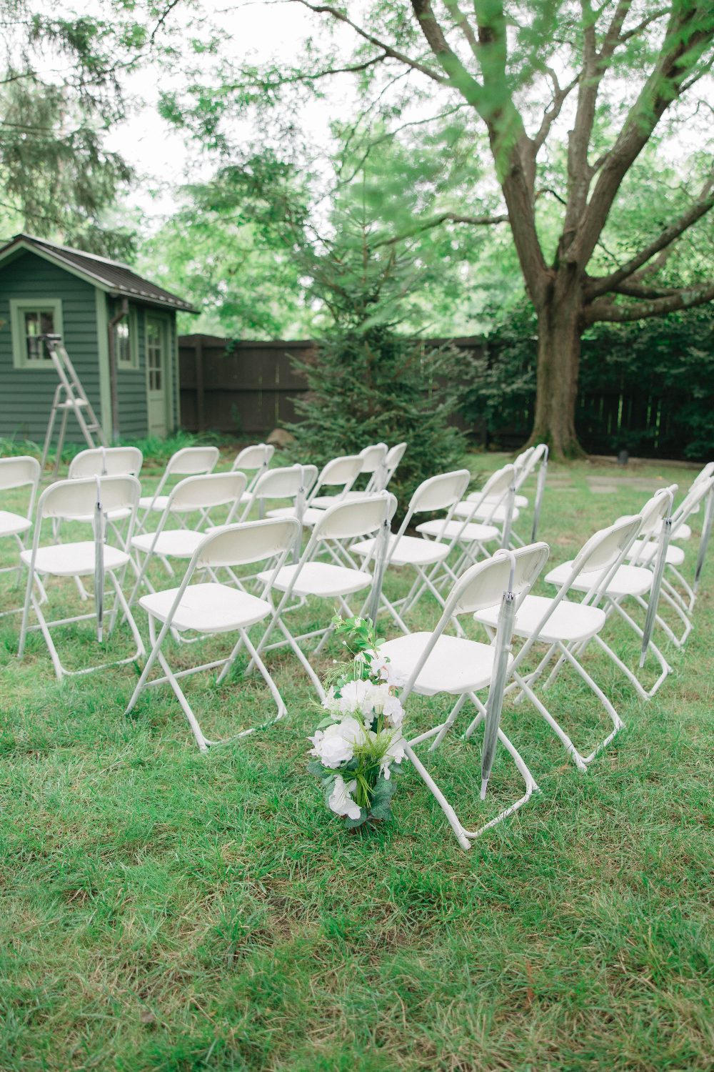 White folding chairs set out on the lawn