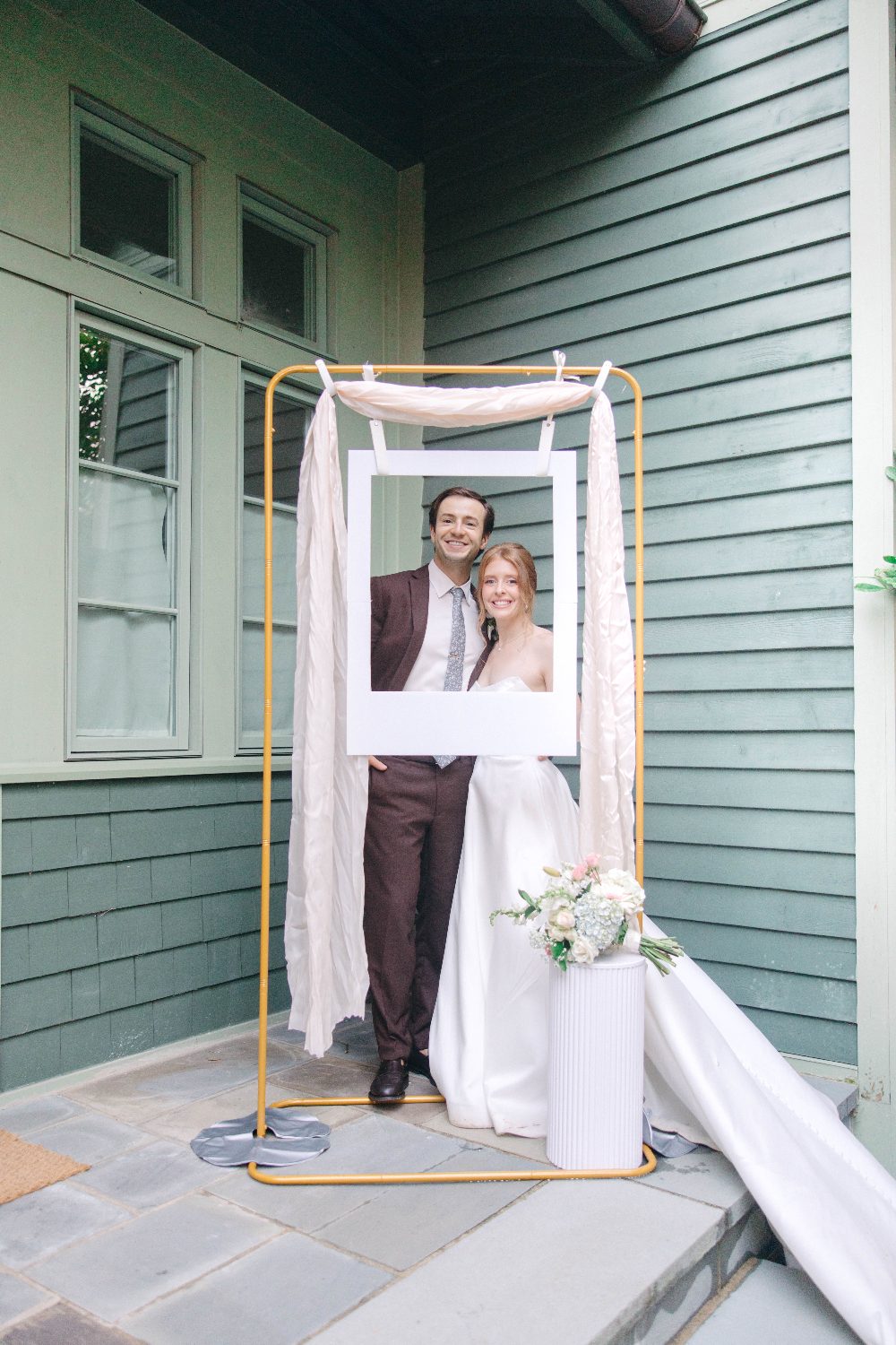 Cody and Katrina posing in the photo frame on the porch