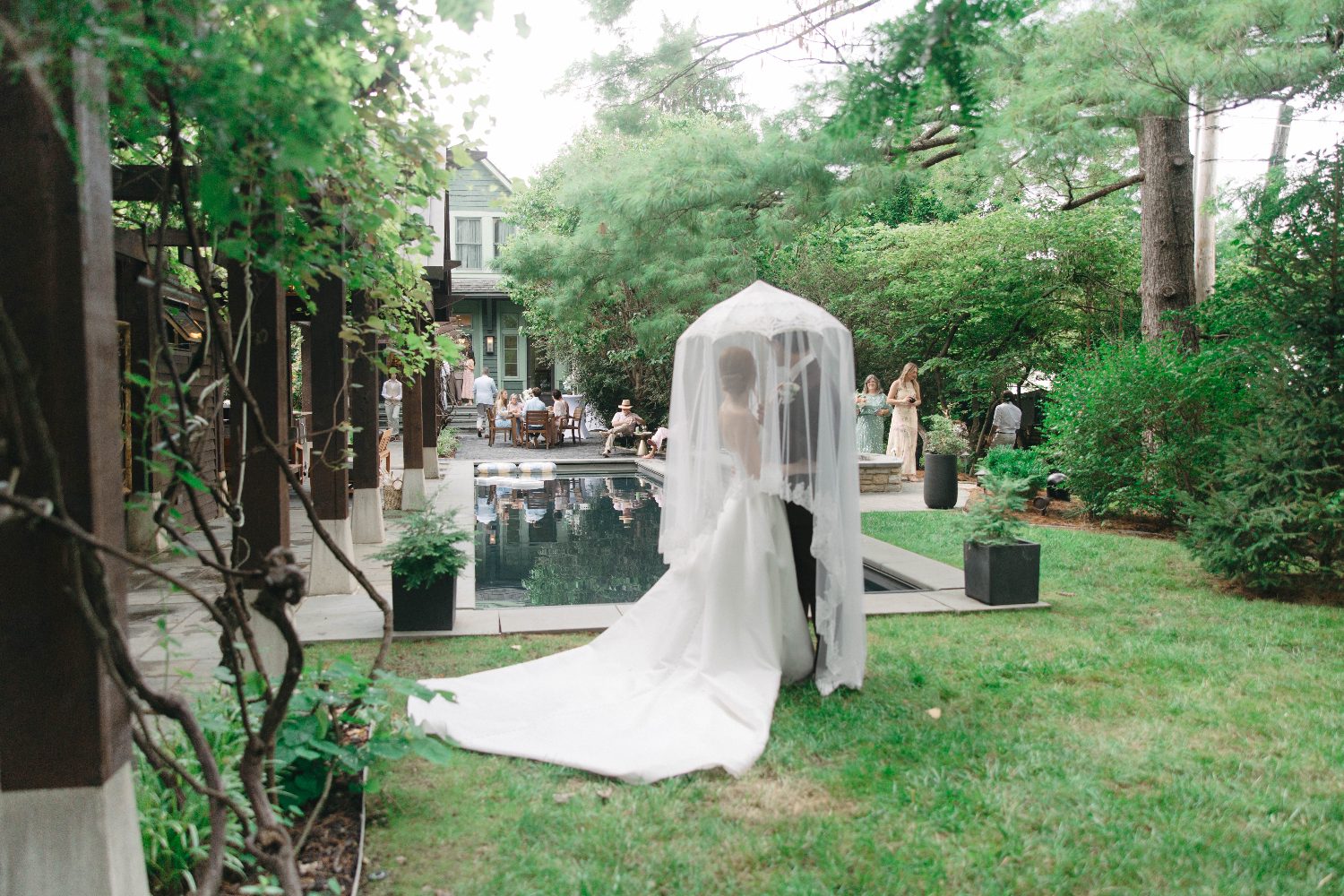 Cody and Katrina under Katrina's veil beside the reflecting pool at The Glenmont House