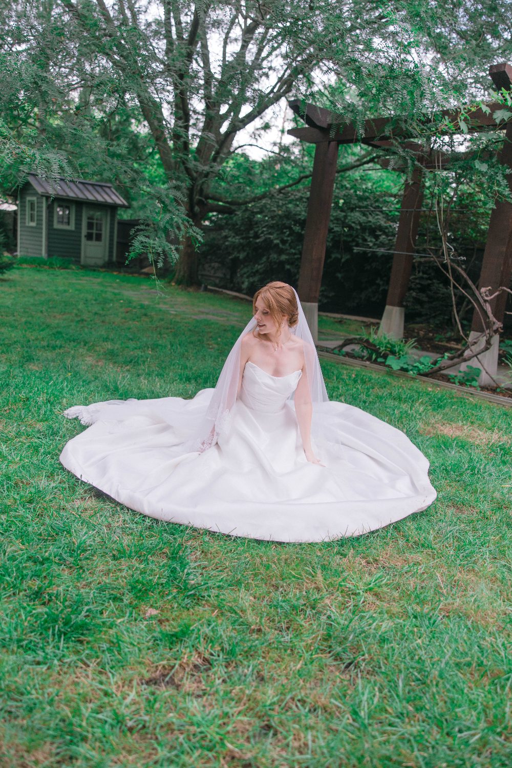 Katrina seated on the lawn with her dress spread out