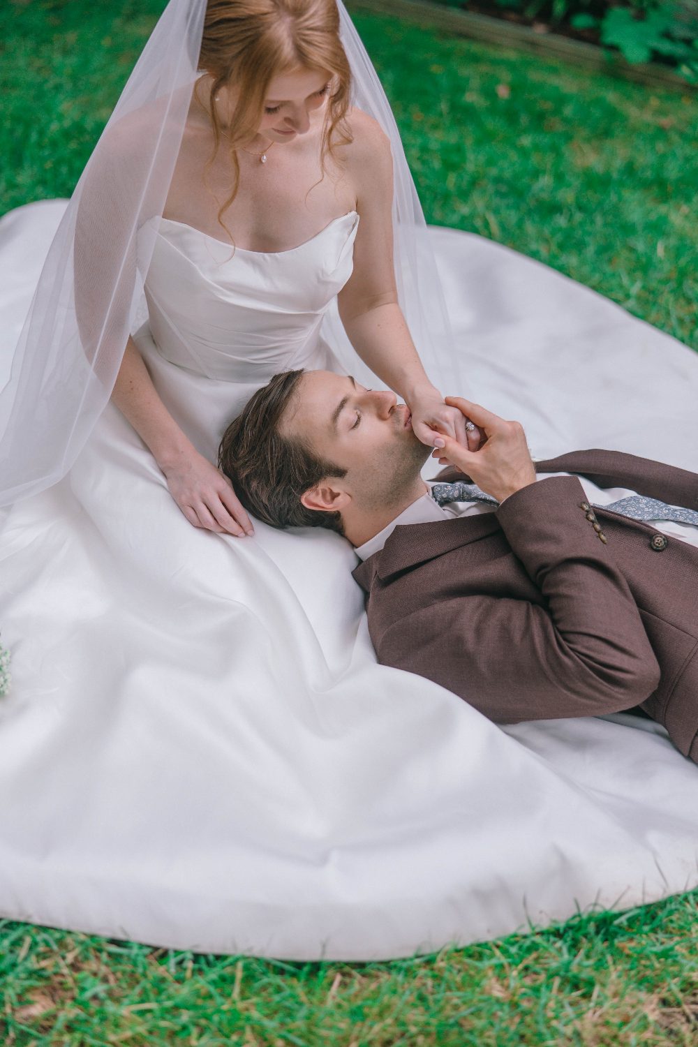 Cody lying on Katrina's dress on the grass